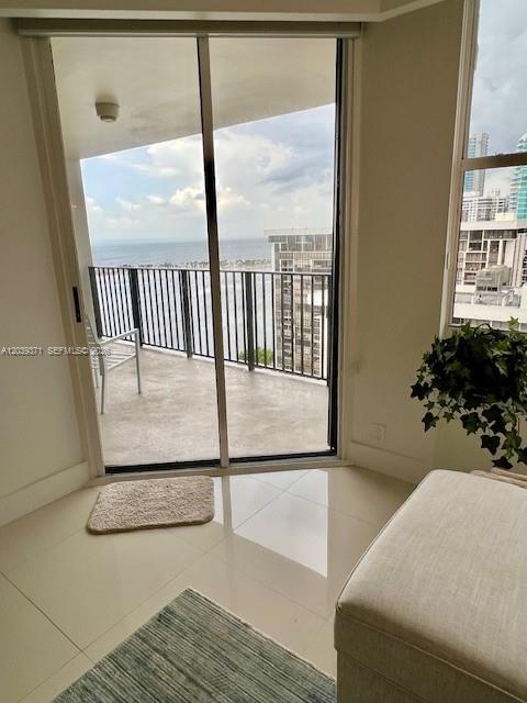 A room with light tile floors, a small rug, and a balcony overlooking the ocean — 1901 BRICKELL AV # B2405, Miami FL 33129, MIAMI, FL