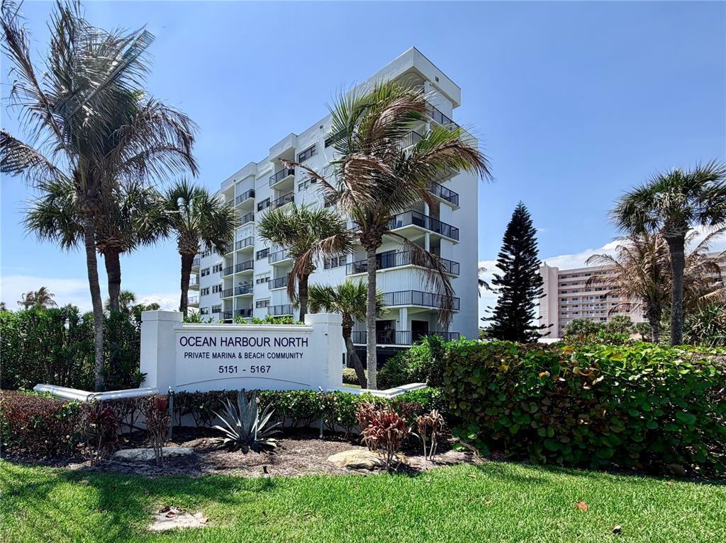 A multi-story white residential building stands behind a sign for Ocean Harbour North — 5151 N HIGHWAY A1A UNIT 212, HUTCHINSON ISLAND, FL
