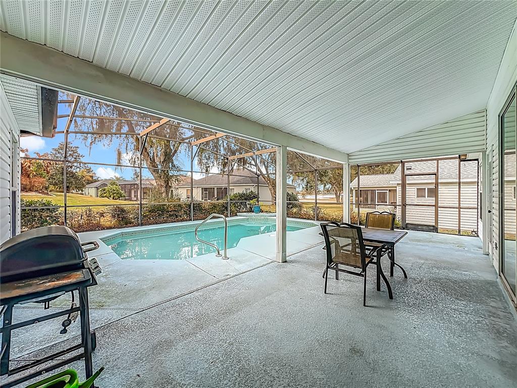 A covered patio with a swimming pool, outdoor dining furniture, and a grill — 3850 PLANTATION BOULEVARD, LEESBURG, FL