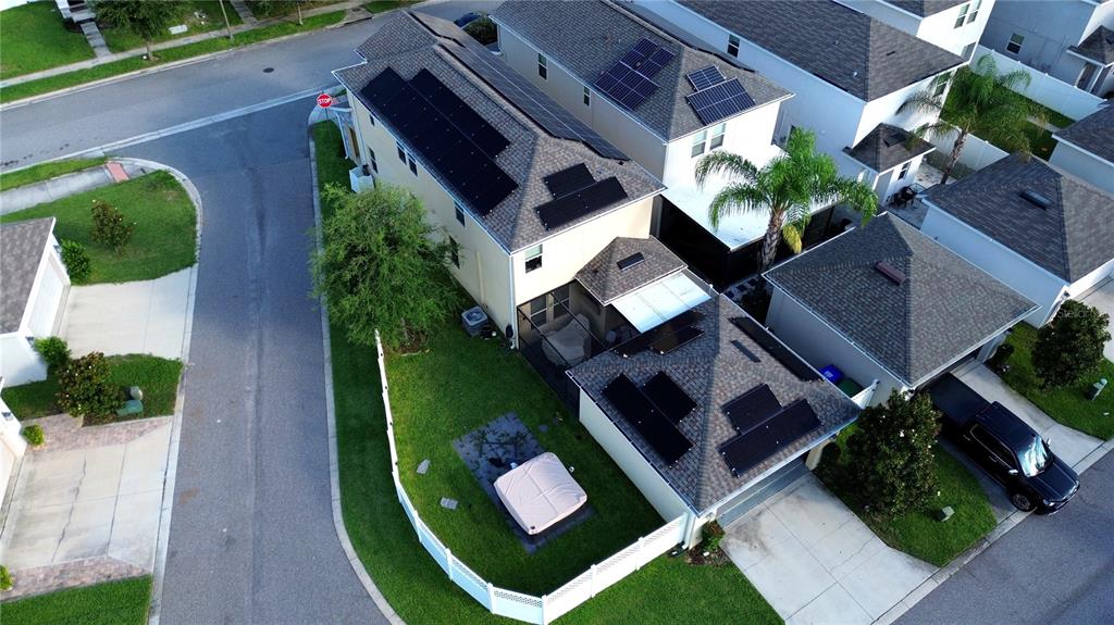 An aerial view shows a two-story house with solar panels on the roof and a backyard — 15175 CHAPTER WAY, WINTER GARDEN, FL