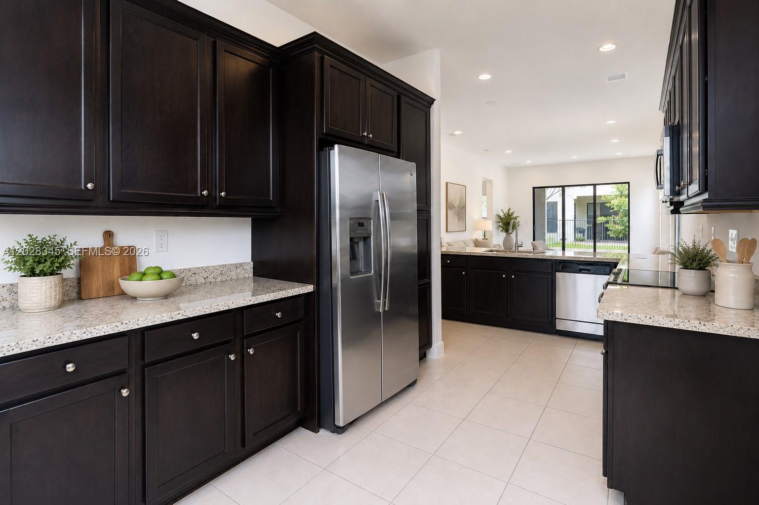 A kitchen features dark wood cabinets, granite countertops, stainless steel appliances, and tile flooring — 9717 W 34th Ln, Hialeah FL 33018, HIALEAH, FL