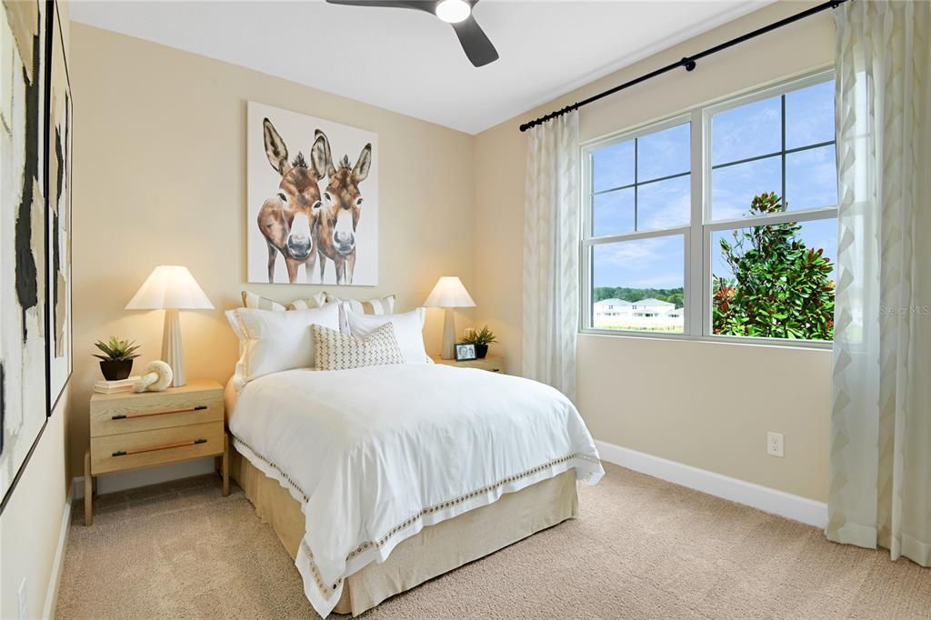 A bedroom features a bed with white bedding, two nightstands, and a donkey wall art piece — 190 BLUE STAR COURT, TAVARES, FL