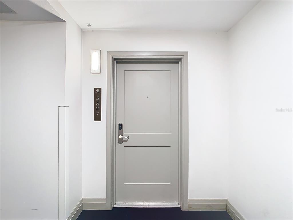 A gray apartment door with a digital lock and unit number sign in a hallway — 14501 GROVE RESORT AVENUE UNIT 3327, WINTER GARDEN, FL