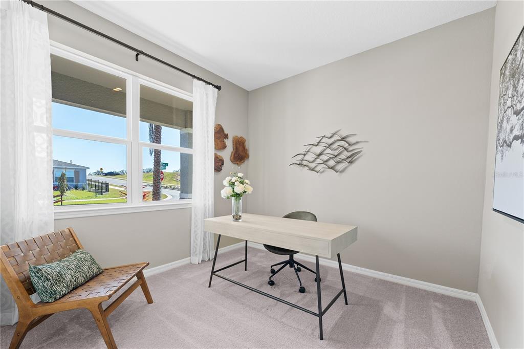 A home office features a light wood desk, a chair, and a window with outdoor views — 6751 WINTERBERRY DRIVE, LAKE HAMILTON, FL