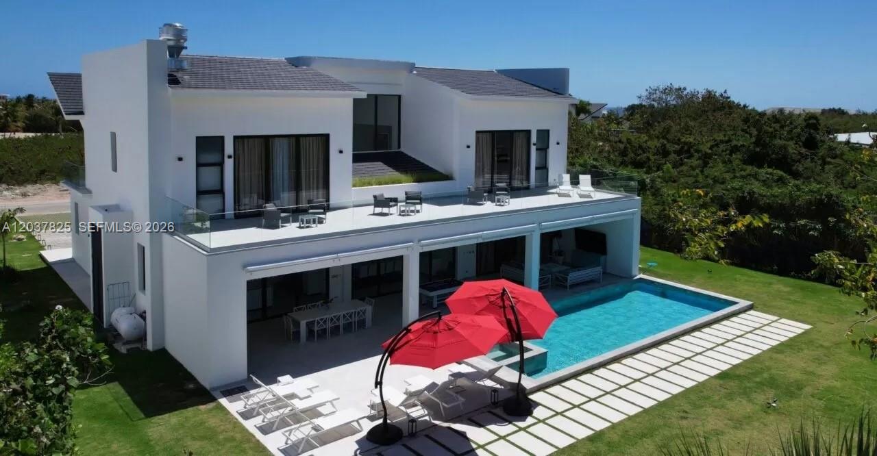 A modern two-story white house features a swimming pool, patio, and upper-level balcony — 0 l palmas, FL