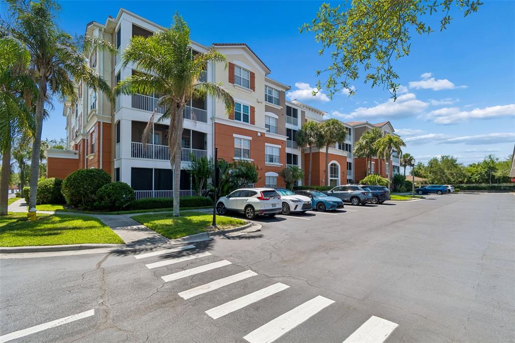 A multi-story apartment building with a parking lot and a crosswalk in the foreground — 7903 SEMINOLE BOULEVARD UNIT 2401, SEMINOLE, FL