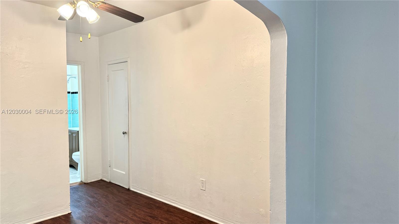 A room with dark wood-look flooring, a white door, and an arched entryway — 4410 NE 2nd Ave # 4414, Miami FL 33137, MIAMI, FL