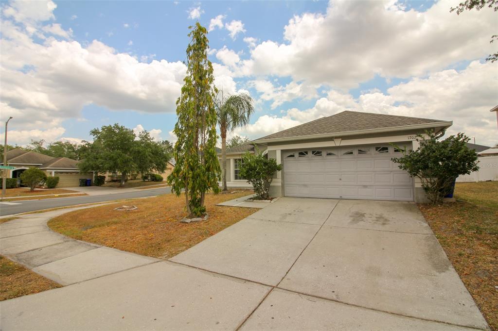 A single-story house with a concrete driveway, a two-car garage, and a front yard — 1702 HOLTON ROAD, LAKELAND, FL