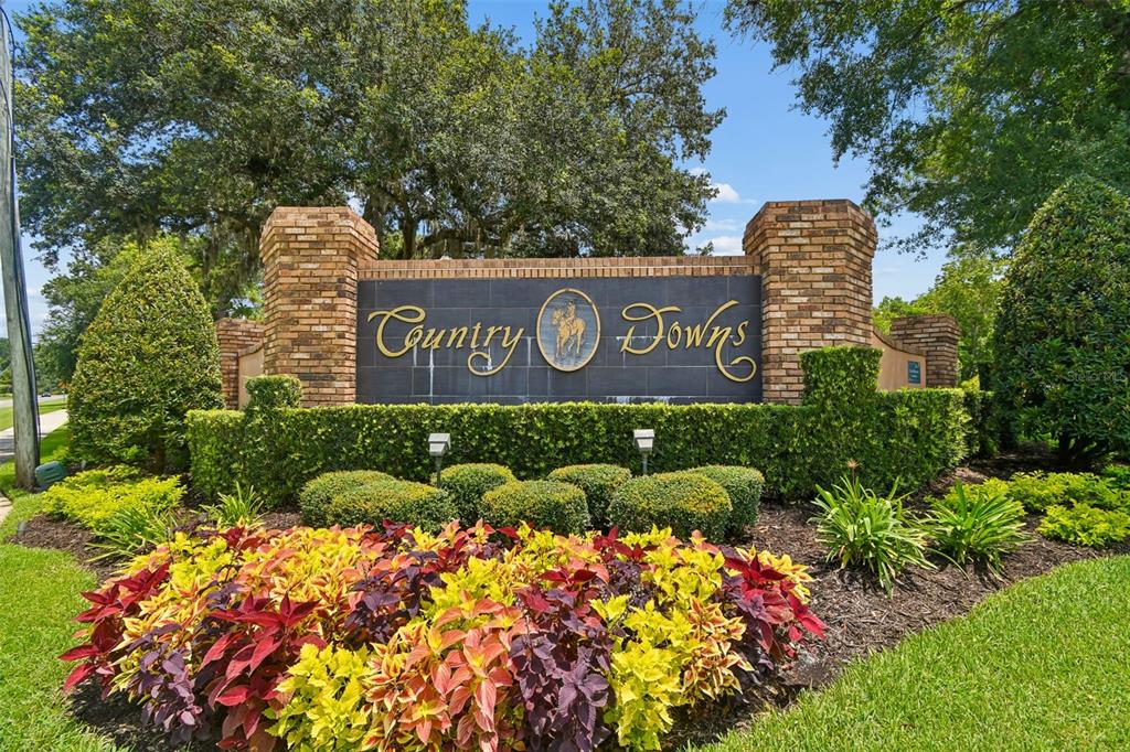 A brick monument sign for Country Downs stands behind a colorful garden bed — 755 KEENELAND PIKE, LAKE MARY, FL