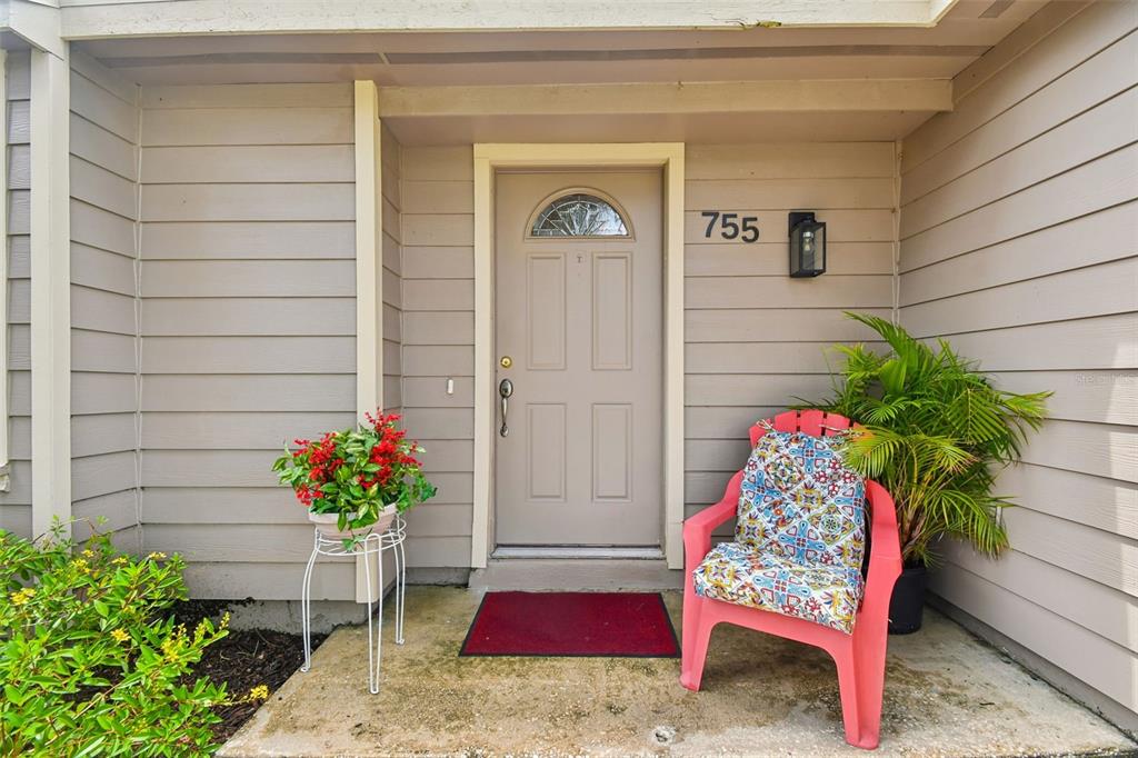The exterior entrance features a tan door, a red welcome mat, and a pink chair — 755 KEENELAND PIKE, LAKE MARY, FL