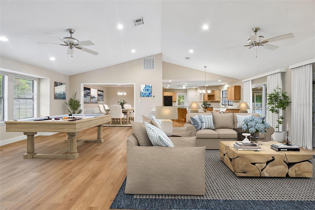 This open-concept living area features a pool table, beige furniture, and light wood flooring — 755 KEENELAND PIKE, LAKE MARY, FL