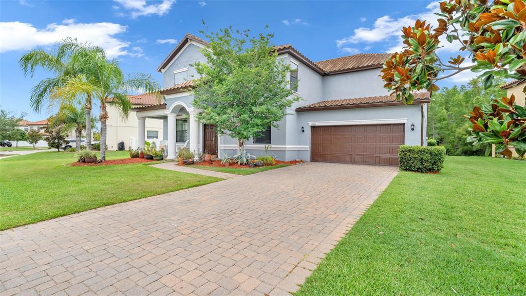 A two-story house with a paved driveway, a brown garage door, and a front porch — 19265 UMBERLAND PLACE, LAND O LAKES, FL