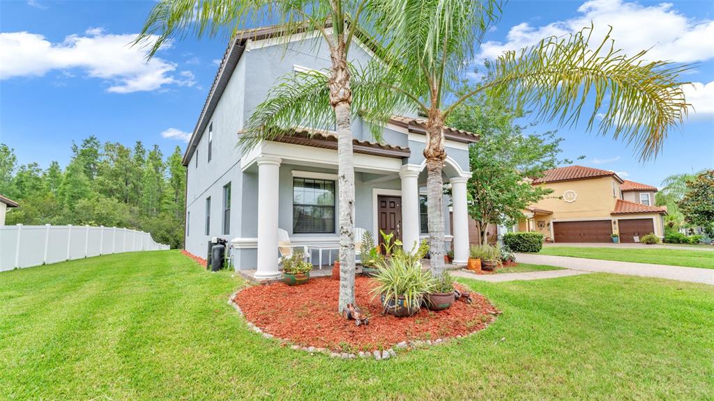 A two-story house with a gray exterior, a front porch, and palm trees in front — 19265 UMBERLAND PLACE, LAND O LAKES, FL