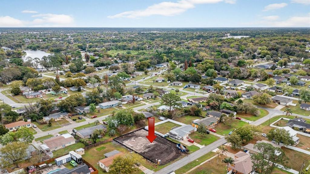 A light gray house exterior features a dark front door, shutters, and a concrete walkway — 897 PICASSO AVENUE, DELTONA, FL