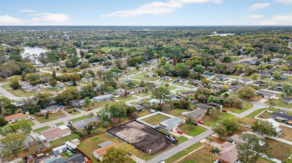 A single-story house with a light-colored stucco exterior, a two-car garage, and a concrete driveway — 897 PICASSO AVENUE, DELTONA, FL