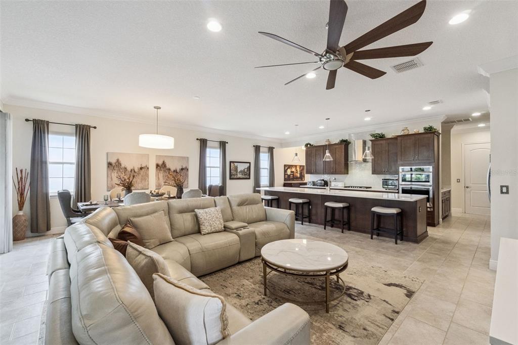 A spacious open-concept living room features a large sectional sofa, dining area, and kitchen island — 2777 SOUTHLAND STREET, ST CLOUD, FL