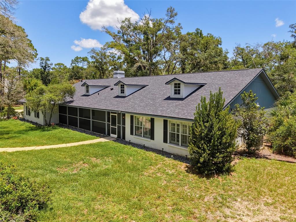 A single-story house with a screened-in porch, dormer windows, and a gray shingled roof — 15234 SCANIO, SPRING HILL, FL