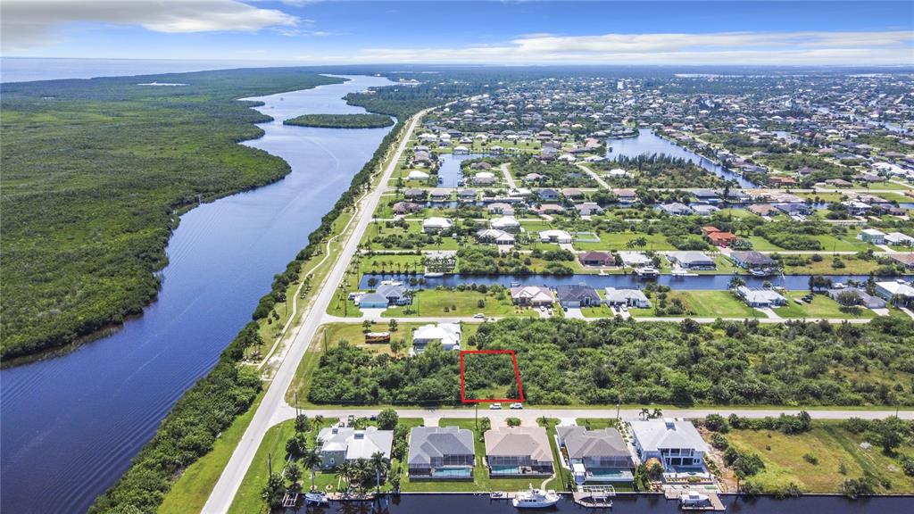 An aerial view shows a vacant, rectangular lot outlined in red within a residential neighborhood — 15419 MARGO CIRCLE, PORT CHARLOTTE, FL