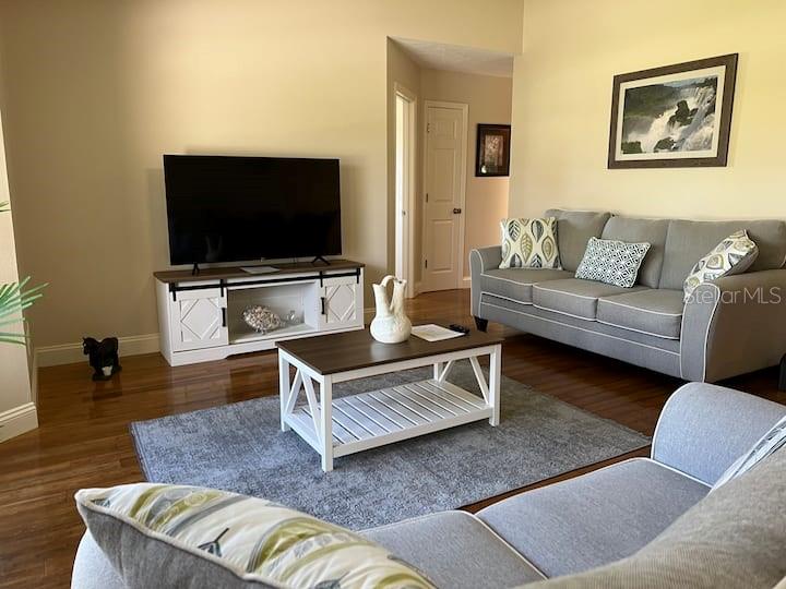 A living room features a grey sofa, a coffee table, and a white media console — 87 MARK TWAIN LANE, ROTONDA WEST, FL