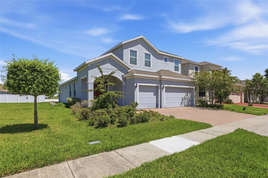 A two-story house with a light blue exterior, a two-car garage, and a front lawn — 2252 RUSH BAY WAY, ORLANDO, FL