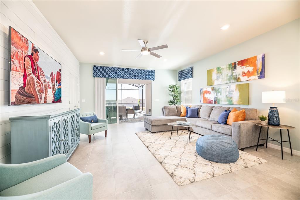 A living room features a large sectional sofa, a television, and a sliding glass door — 3783 LANA AVENUE, DAVENPORT, FL