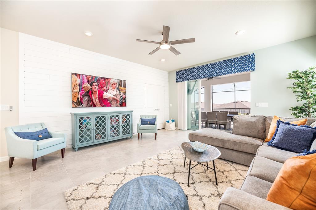 A living room features a shiplap wall, a gray sectional, and a blue media console — 3783 LANA AVENUE, DAVENPORT, FL