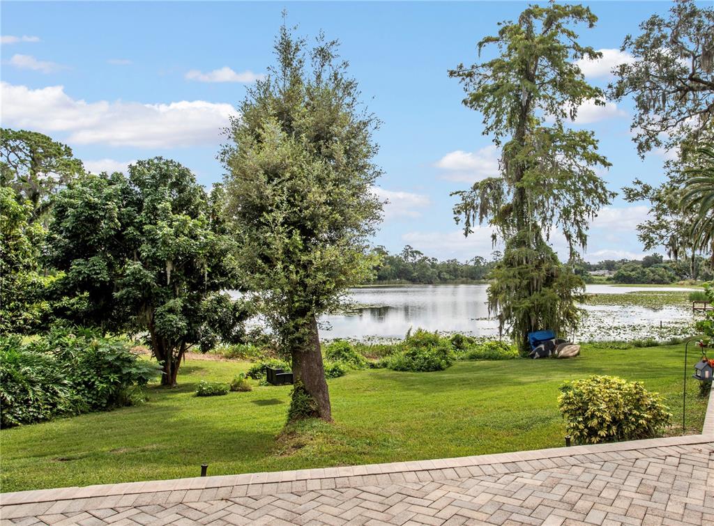 A two-story house with a beige exterior, black garage doors, and a circular garden statue — 4574 SAILBREEZE COURT, ORLANDO, FL