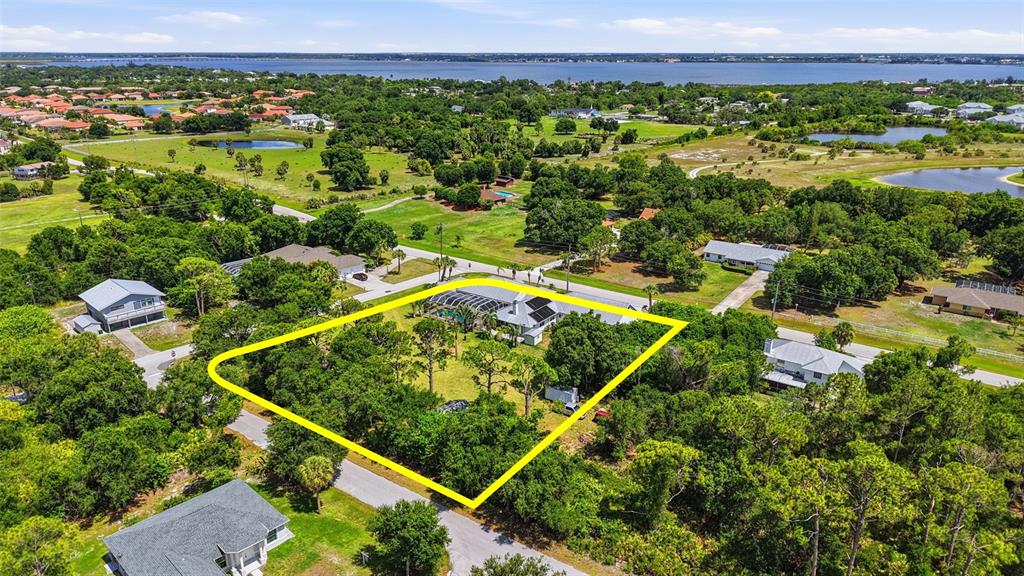 An aerial view shows a house with a pool enclosure highlighted by a yellow border — 23494 WESTCHESTER BOULEVARD, PUNTA GORDA, FL