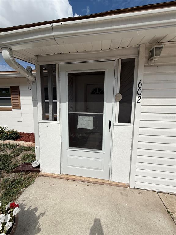 The exterior view shows a white front door with a screen and house number 602 — 602 SULLIVAN AVENUE, OCOEE, FL