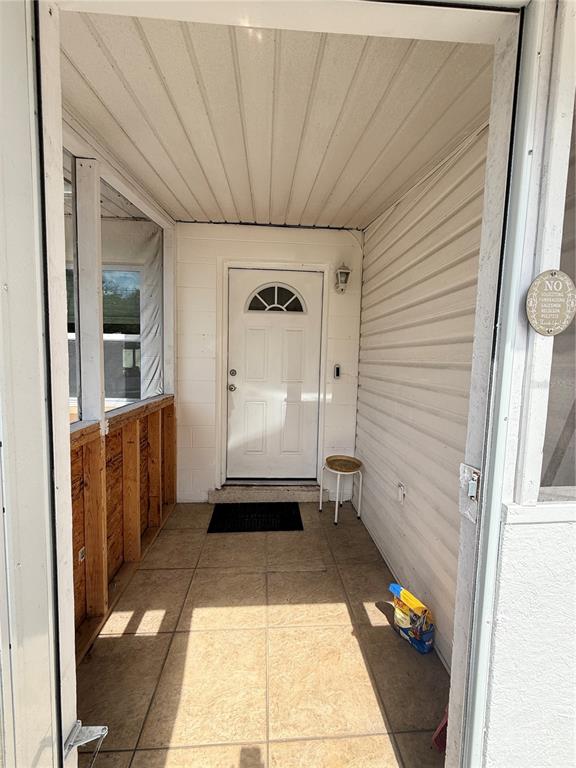 A covered porch features tiled flooring, white siding, and a white front door — 602 SULLIVAN AVENUE, OCOEE, FL
