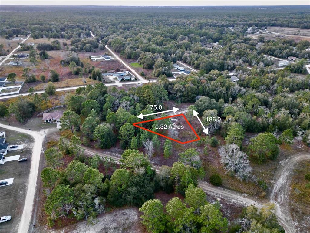 An aerial view shows a vacant, wooded lot outlined in red with dimensions labeled — TBD SW 145TH CT, OCALA, FL