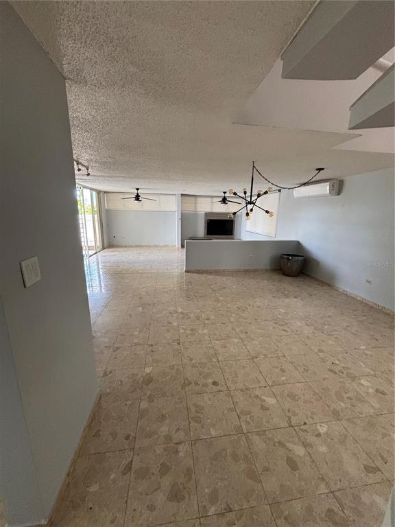 An open-concept living area features light-colored tile flooring, a modern chandelier, and a ceiling fan — Calle 3 PASEO LAS VISTAS, SAN JUAN, PR