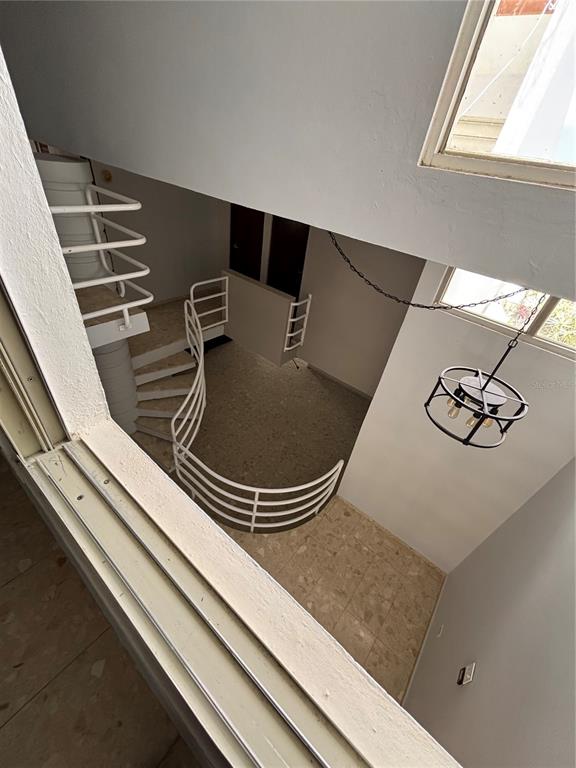 A high-angle view shows a spiral staircase and a hanging light fixture in a room — Calle 3 PASEO LAS VISTAS, SAN JUAN, PR