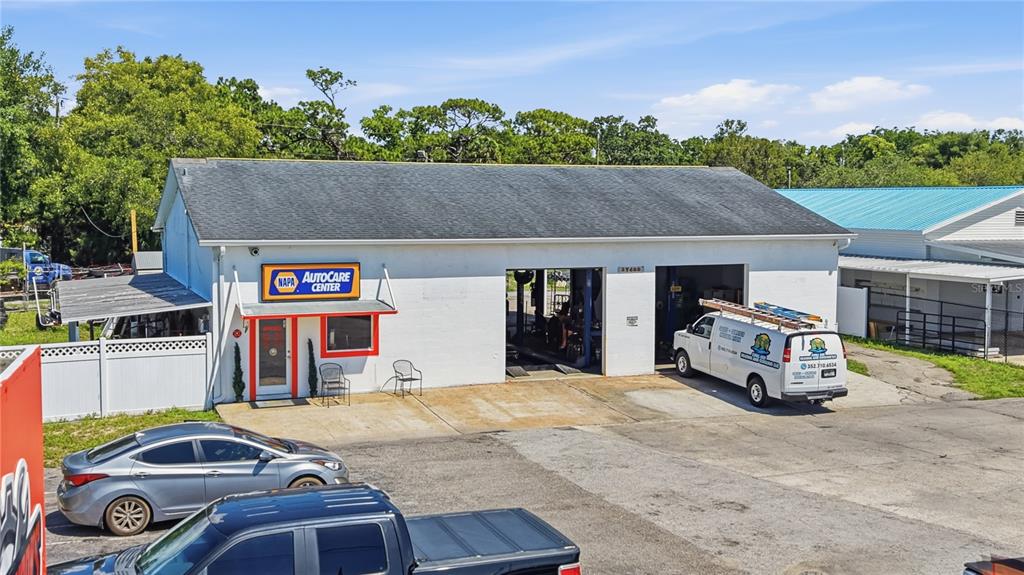 An exterior view of a white NAPA AutoCare Center building with two open service bays — 17426 US HWY 19, HUDSON, FL