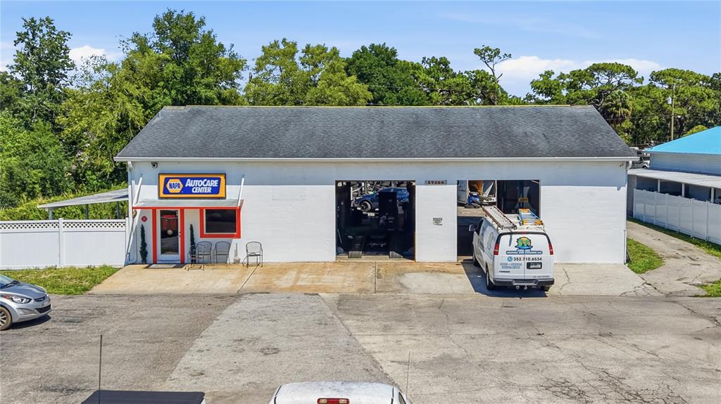 An exterior view of a white commercial building with two garage bays and a NAPA sign — 17426 US HWY 19, HUDSON, FL