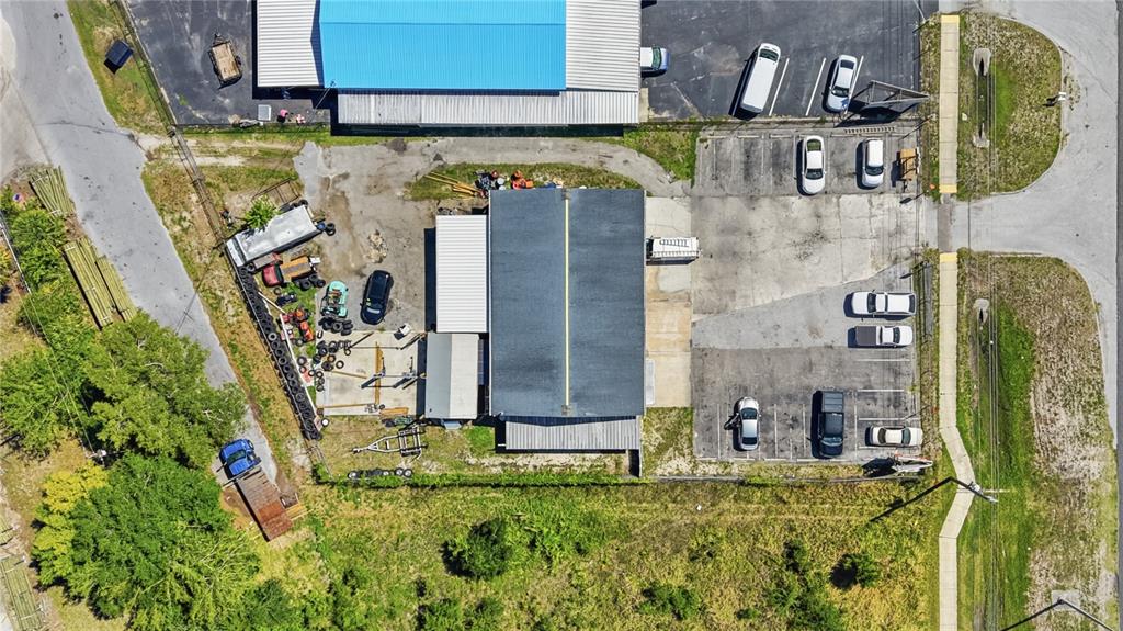 An aerial view shows a commercial building with a parking lot and outdoor storage area — 17426 US HWY 19, HUDSON, FL