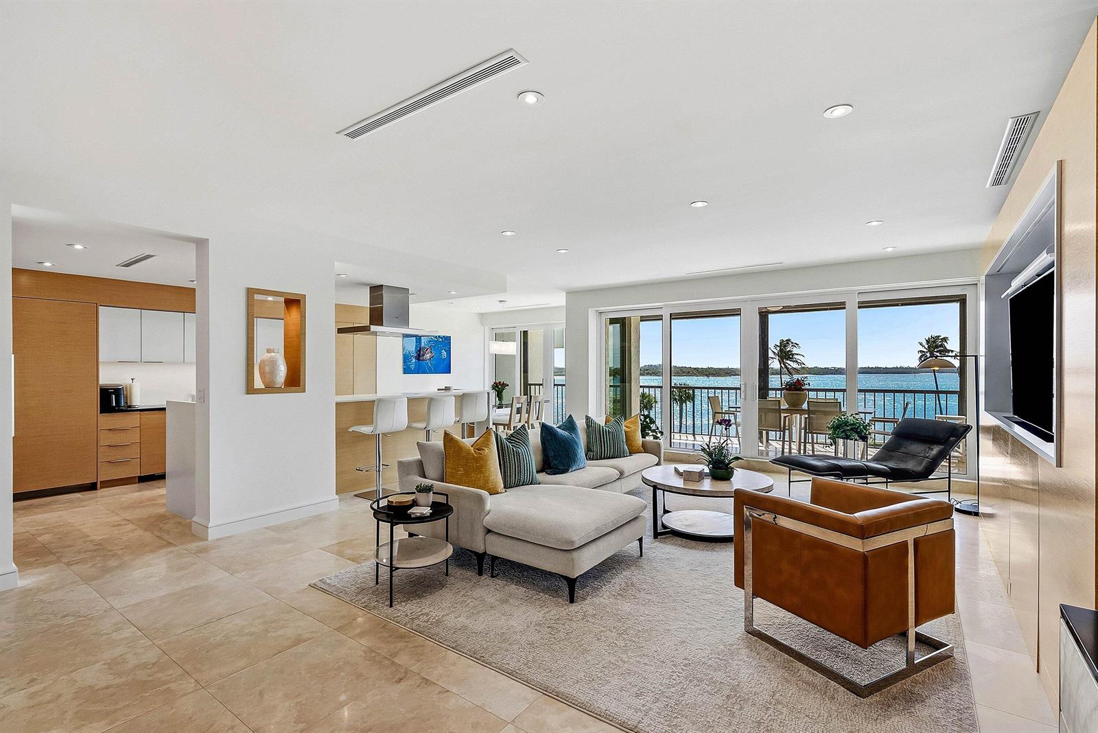 A modern living room with a sectional sofa, leather chair, and balcony overlooking the ocean — 2820 SE Dune Drive # 2306, Stuart FL 34996, STUART, FL