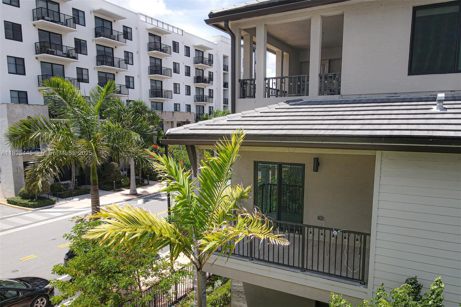 An exterior view shows a multi-story building with balconies and a palm tree — 4269 NW 83rd Path, Doral FL 33166, DORAL, FL