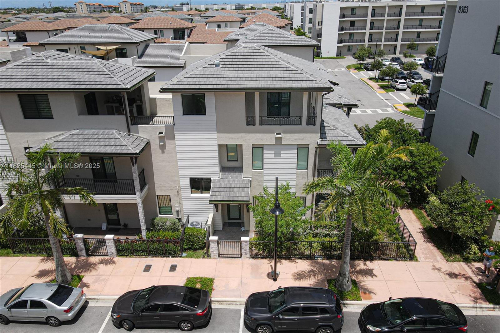An exterior view of a multi-story residential building with gray tile roofs and palm trees — 4269 NW 83rd Path, Doral FL 33166, DORAL, FL
