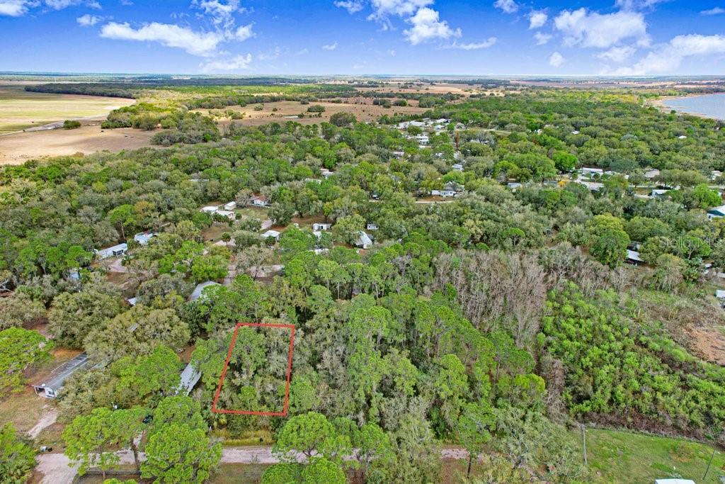 An aerial view shows a rectangular plot of land outlined in red amidst wooded terrain — 0 YUCATAN DRIVE, LAKE WALES, FL