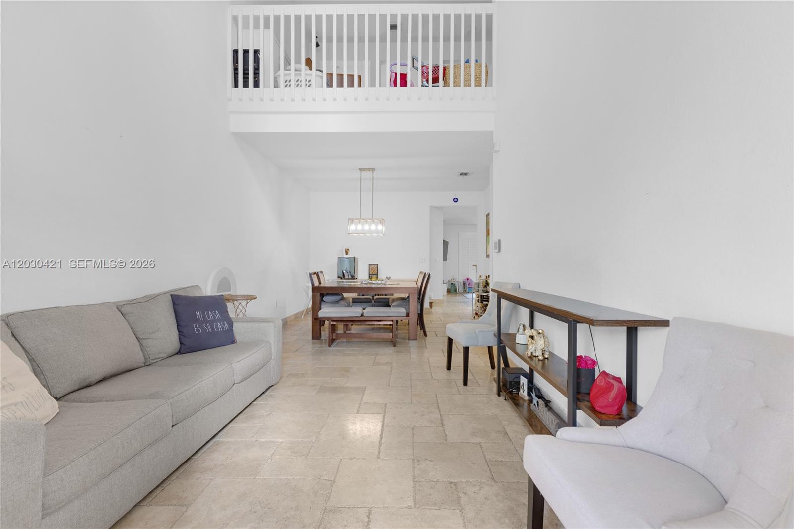 A living and dining area features tile floors, a high ceiling, and a loft balcony — 7475 NW 116th Ave, Doral FL 33178, DORAL, FL