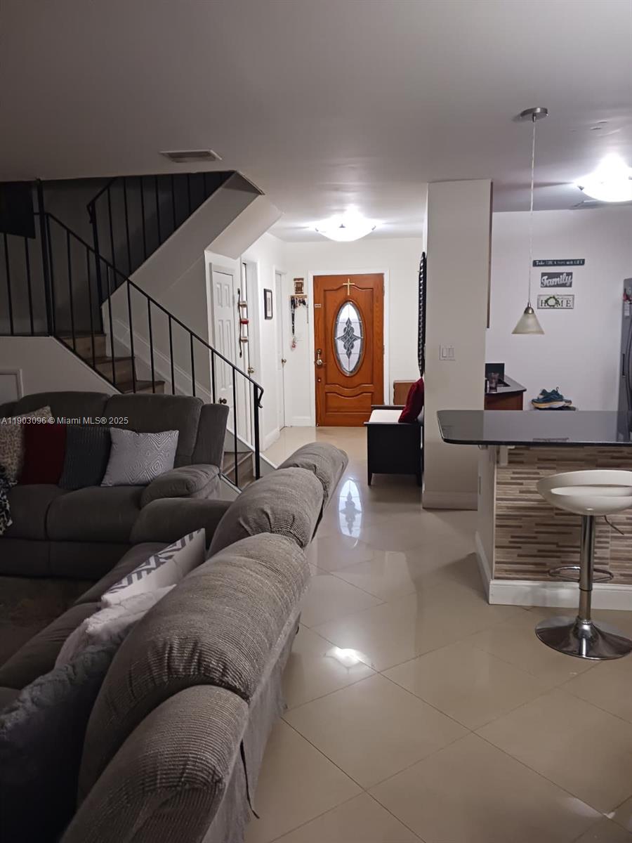 A living room with a staircase, tile flooring, and a kitchen counter with a stool — 8340 SW 154th Ave # 63, Miami FL 33193, MIAMI, FL