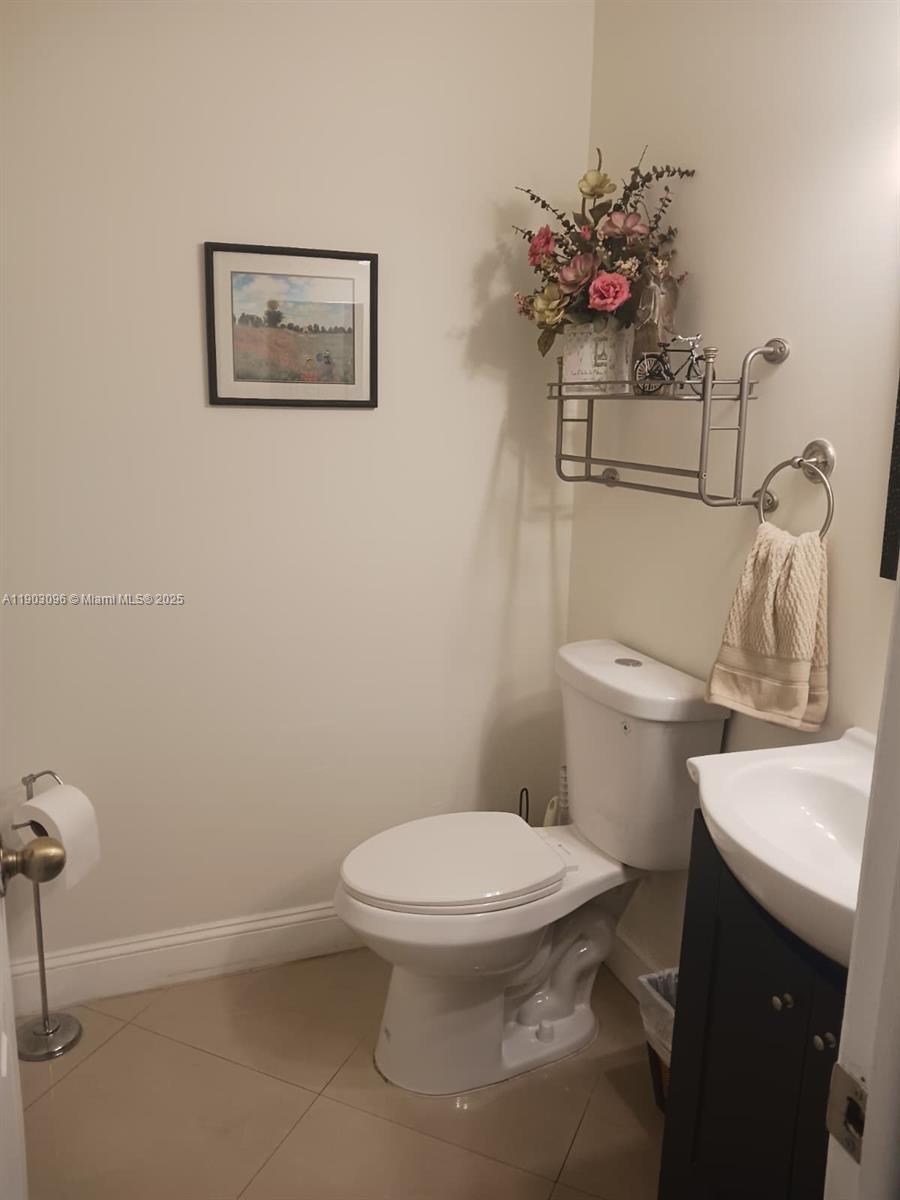 A small bathroom features a white toilet, a dark vanity with a sink, and wall-mounted shelving — 8340 SW 154th Ave # 63, Miami FL 33193, MIAMI, FL