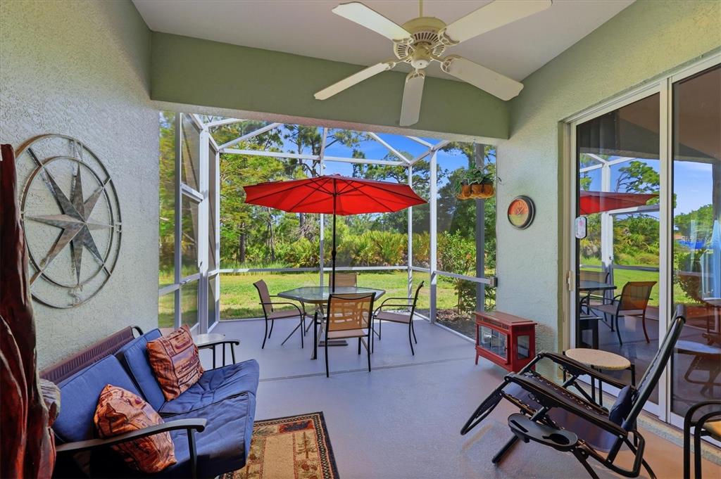 A screened-in patio features a ceiling fan, outdoor furniture, and a view of the yard — 1528 SCARLETT AVENUE, NORTH PORT, FL