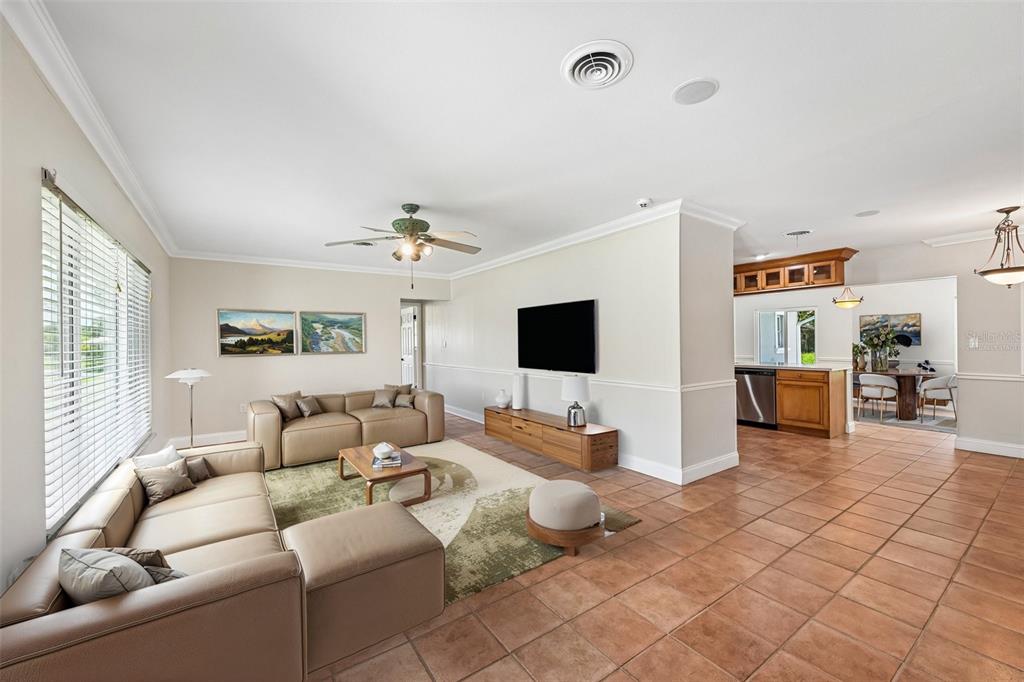 A spacious living room with tile floors, a sectional sofa, and an open-concept kitchen — 209 PALM AVENUE, NOKOMIS, FL