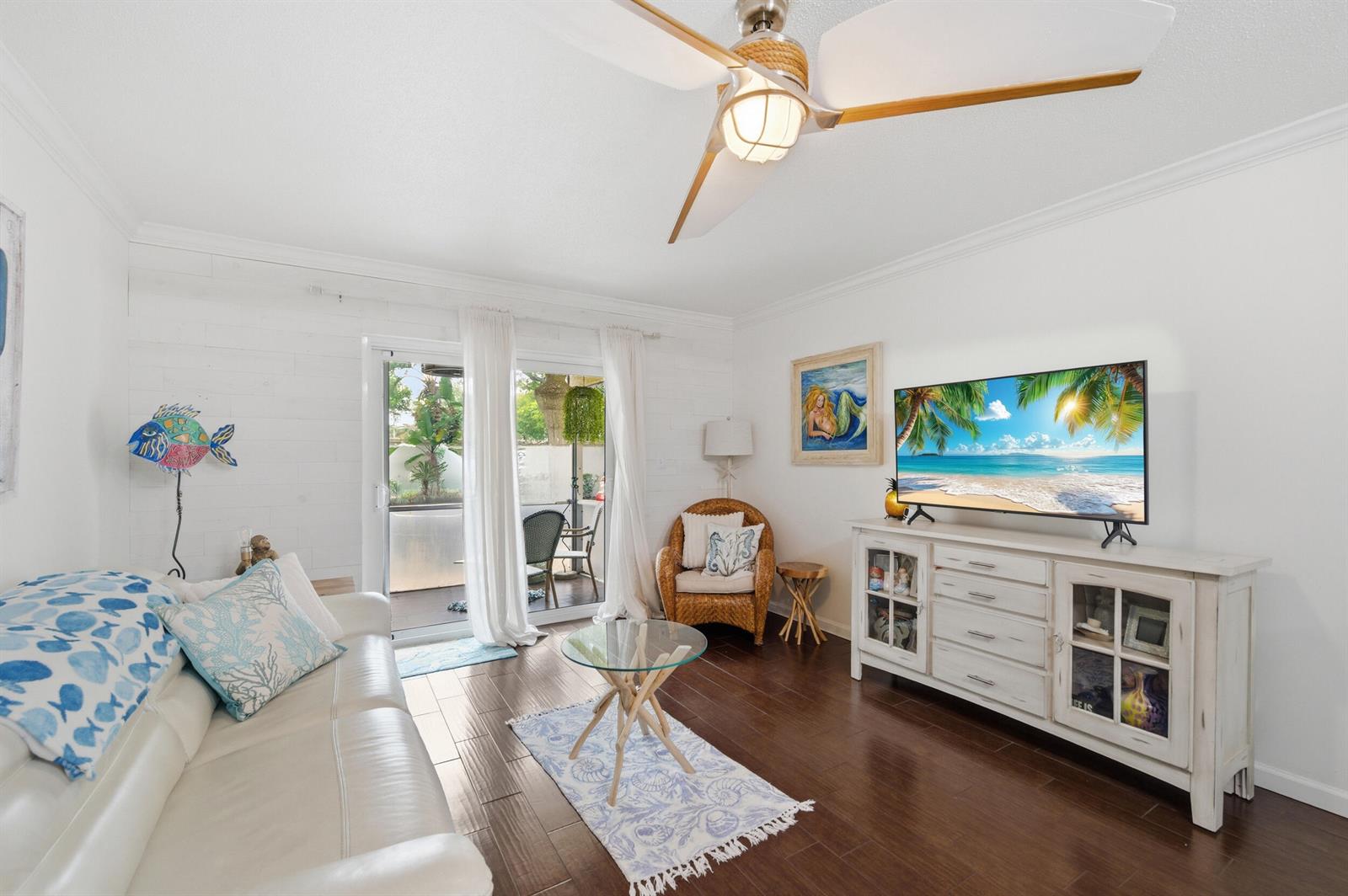 A living room features a white sofa, a glass coffee table, and a television console — 101 E Mcnab Road # 102, Pompano Beach FL 33060, POMPANO BEACH, FL