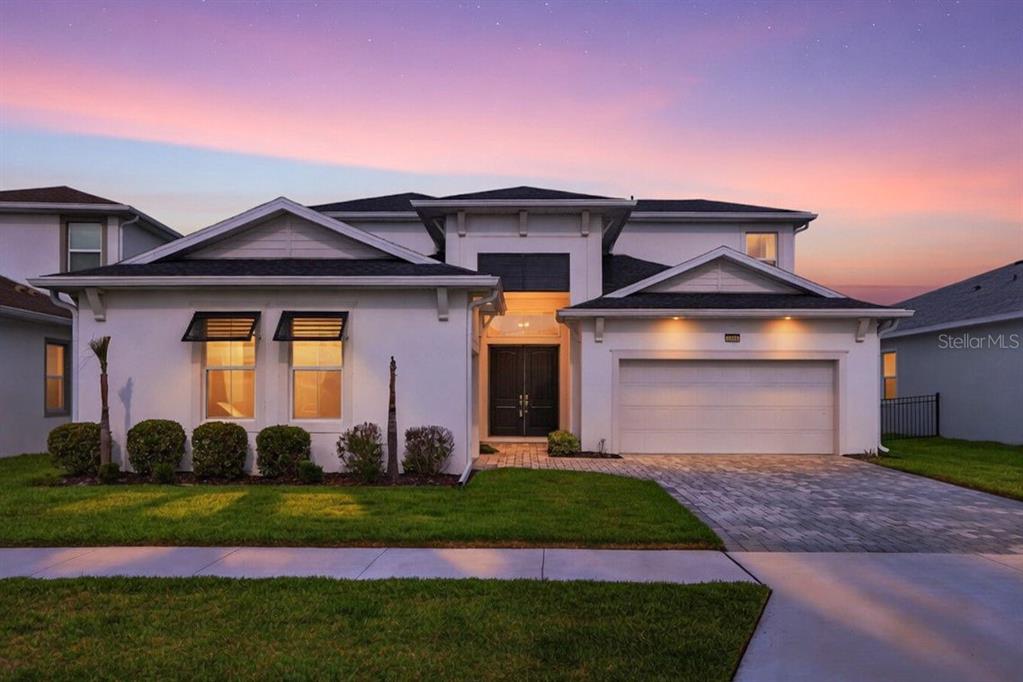 A two-story house with a white exterior, a two-car garage, and a paved driveway — 8346 IVY STARK BOULEVARD, WESLEY CHAPEL, FL