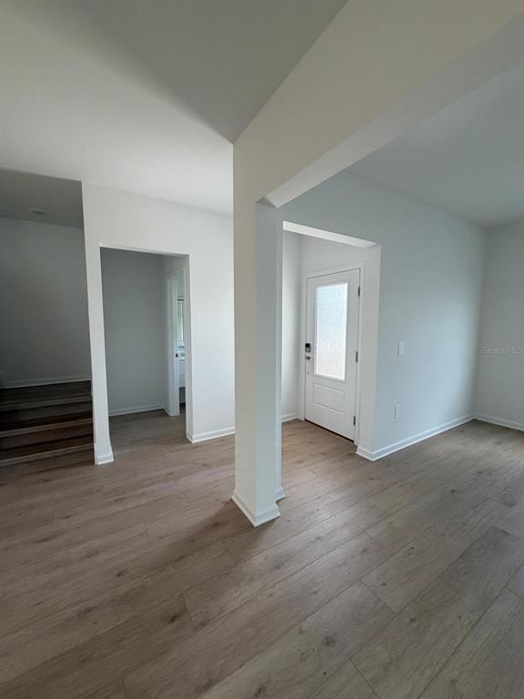An interior view shows a white-walled entryway with light wood-look flooring and a front door — 5175 LOYALTY DRIVE, ST CLOUD, FL