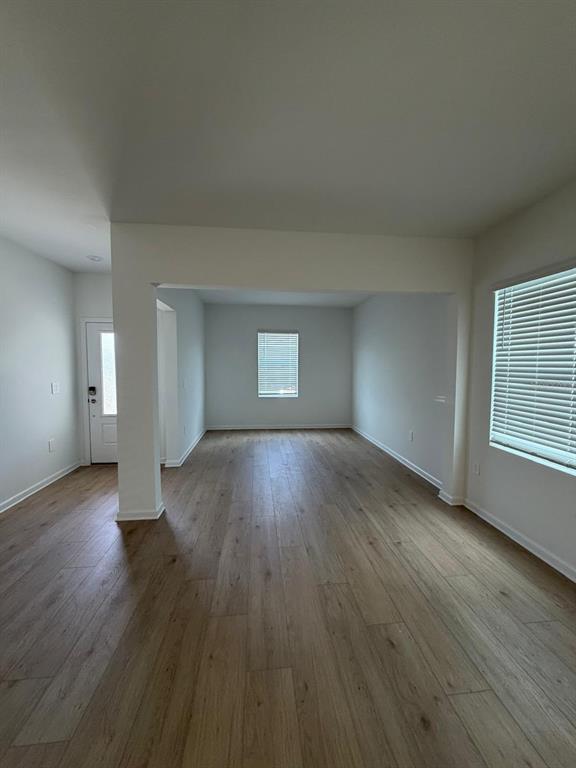 An empty room with light wood-look flooring, white walls, and two windows with blinds — 5175 LOYALTY DRIVE, ST CLOUD, FL