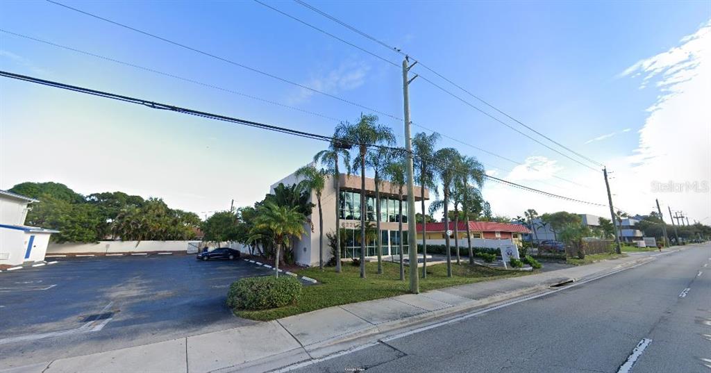 A two-story commercial building with a glass facade stands next to a paved parking lot — 6221 W ATLANTIC BOULEVARD, MARGATE, FL